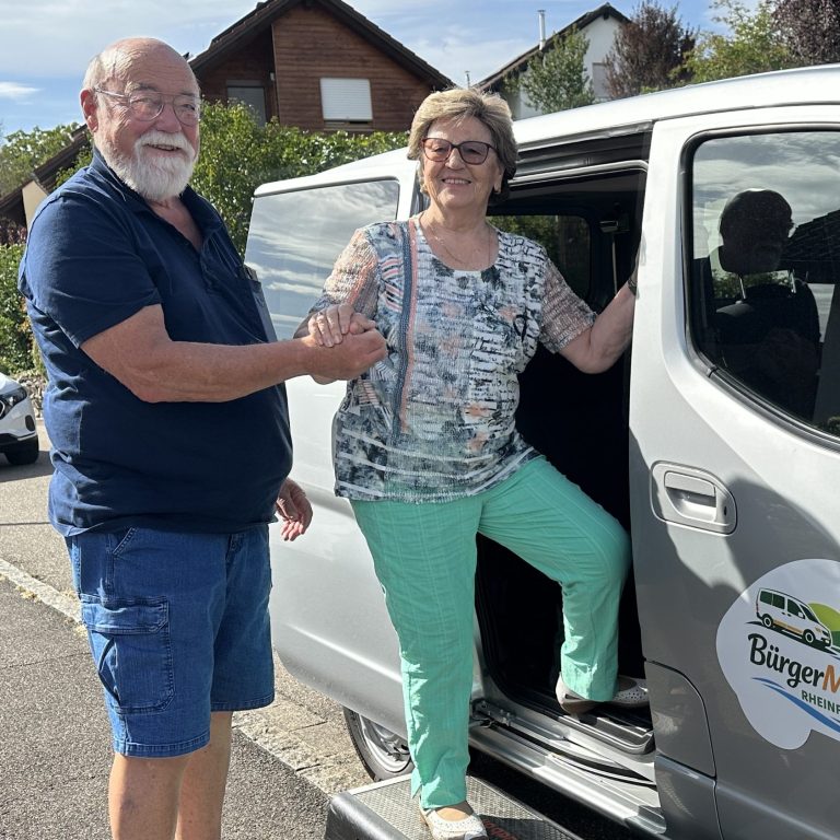 Ein Mann hilft einer älteren Frau ins BürgerMobil Rheinfelden einzusteigen.