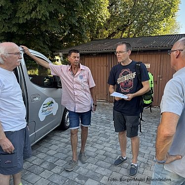 Eine Hand unterschreibt ein Dokument auf einem Tisch.